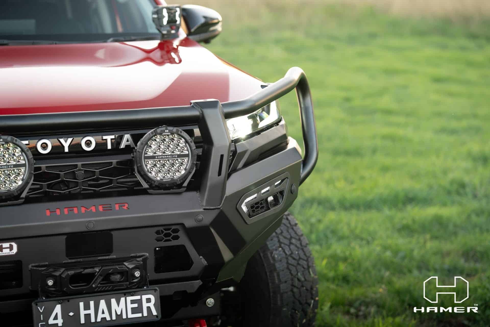 Toyota Hilux with West Coast Off Road Atlas Series Plus bull bar in green field.