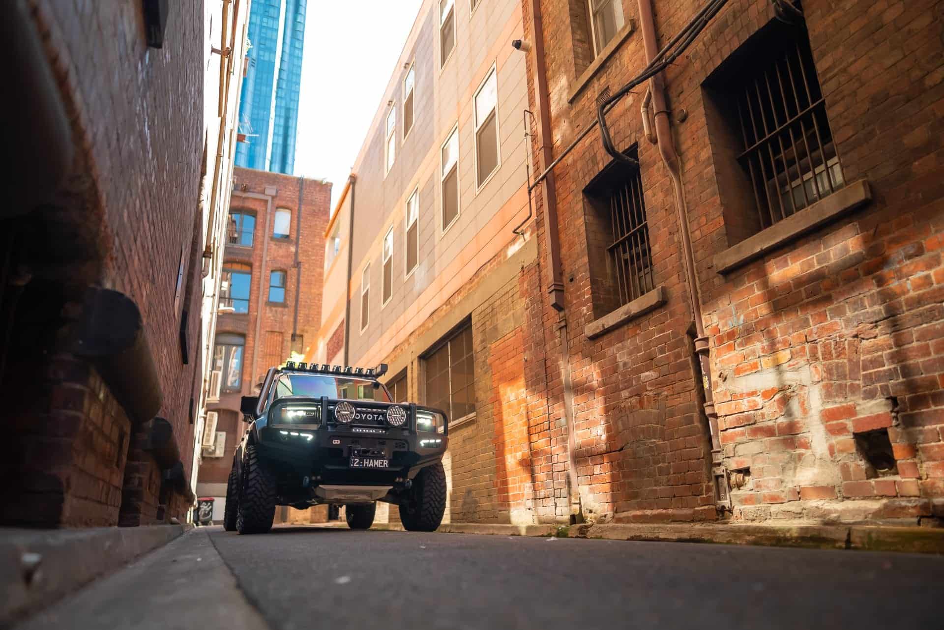 Toyota Landcruiser Prado with West Coast Off Road bull bar in an urban alleyway.