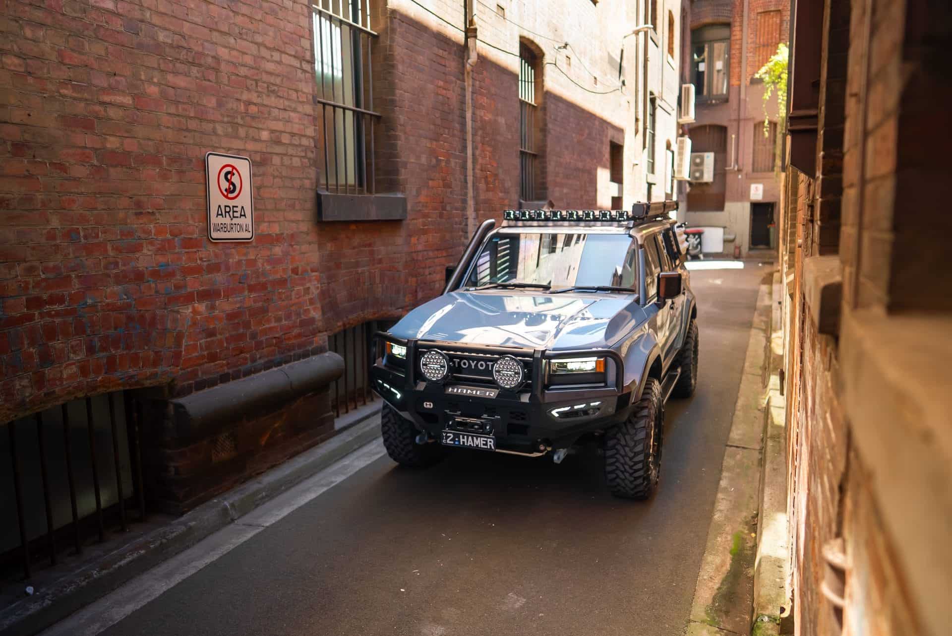 Toyota Landcruiser Prado with off-road accessories in an alleyway.