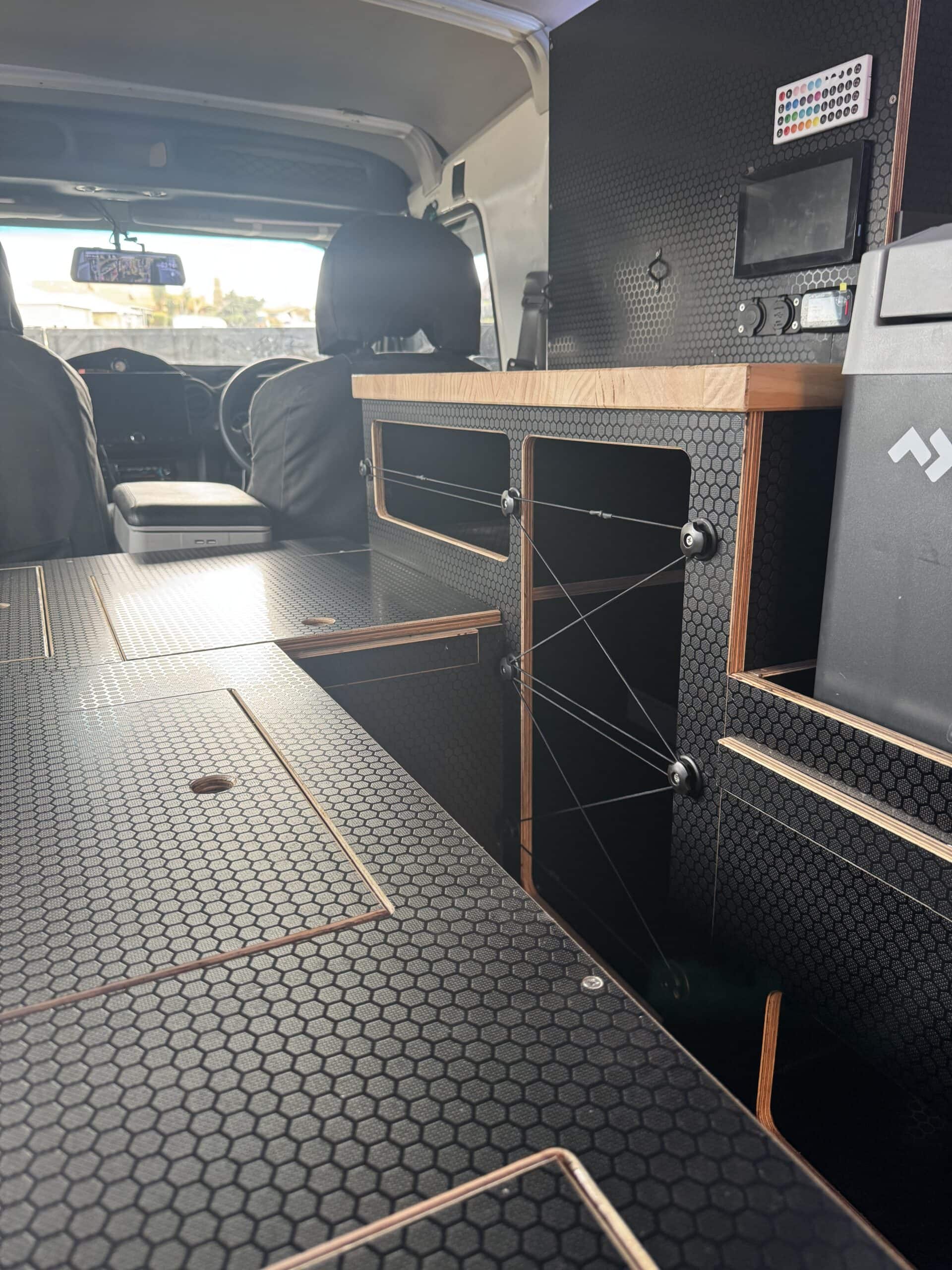 Interior of a custom off-road vehicle with storage and electronic equipment.